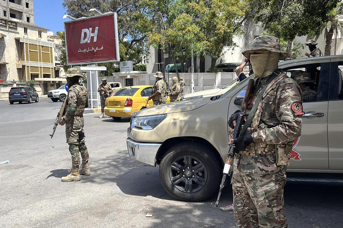 Las fuerzas de seguridad libias hacen guardia en un control de carretera tras los enfrentamientos nocturnos en Trípoli, Libia. Las fuerzas de seguridad libias hacen guardia en un control de carretera tras los enfrentamientos nocturnos en Trípoli, Libia.