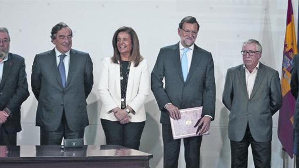 Báñez y Rajoy (en el centro), con los agentes sociales en la firma del pacto sobre la ayuda social en diciembre.
