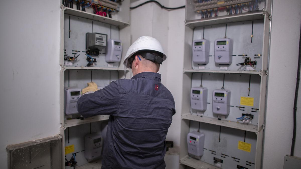 Un técnico de Endesa realiza una reparación en los contadores eléctricos de un edificio.