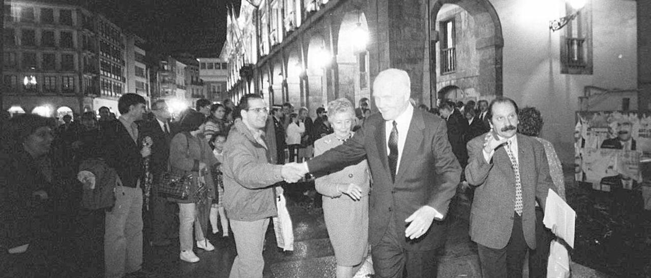 El astronauta John Glenn, en la plaza de España, saluda a un avilesino antes de seguir su marcha hacia el teatro Palacio Valdés.  | Miki López