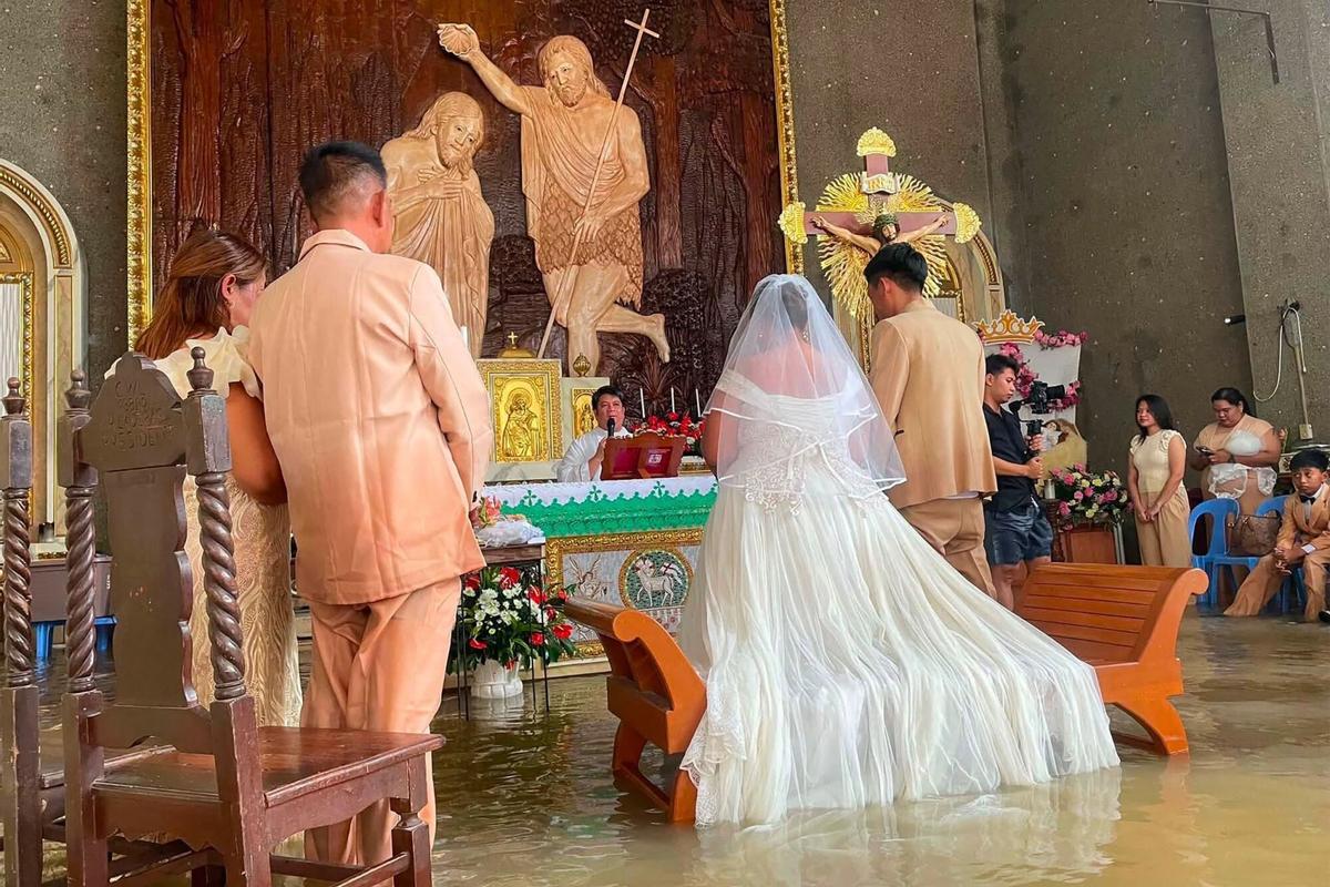 La pareja Leian Lieza Galang y Gilbert Chico frente al altar durante su ceremonia de boda en una iglesia inundada en la ciudad de Hagonoy.