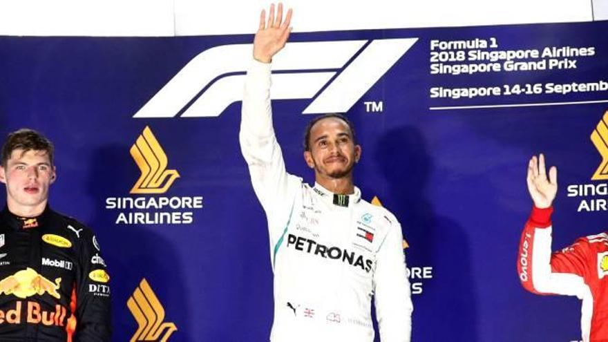 Lewis Hamilton, a l&#039;esglaó més alt del podi de Singapur, acompanyat per Max Verstappen, segon, i Sebastian Vettel, tercer.