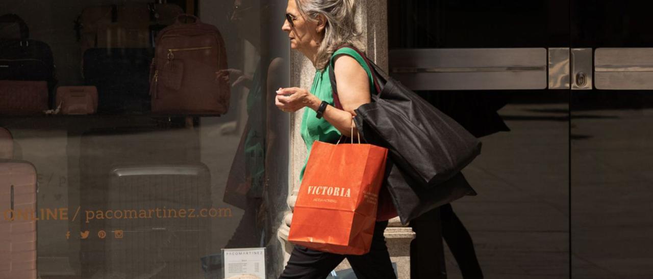 Una mujer, con varias bolsas, por una calle del centro de Zamora. |