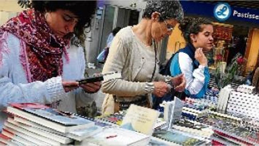 Petits i grans remenant llibres en una parada de Sant Jordi que hi havia al Passeig de Manresa l&#039;any passat