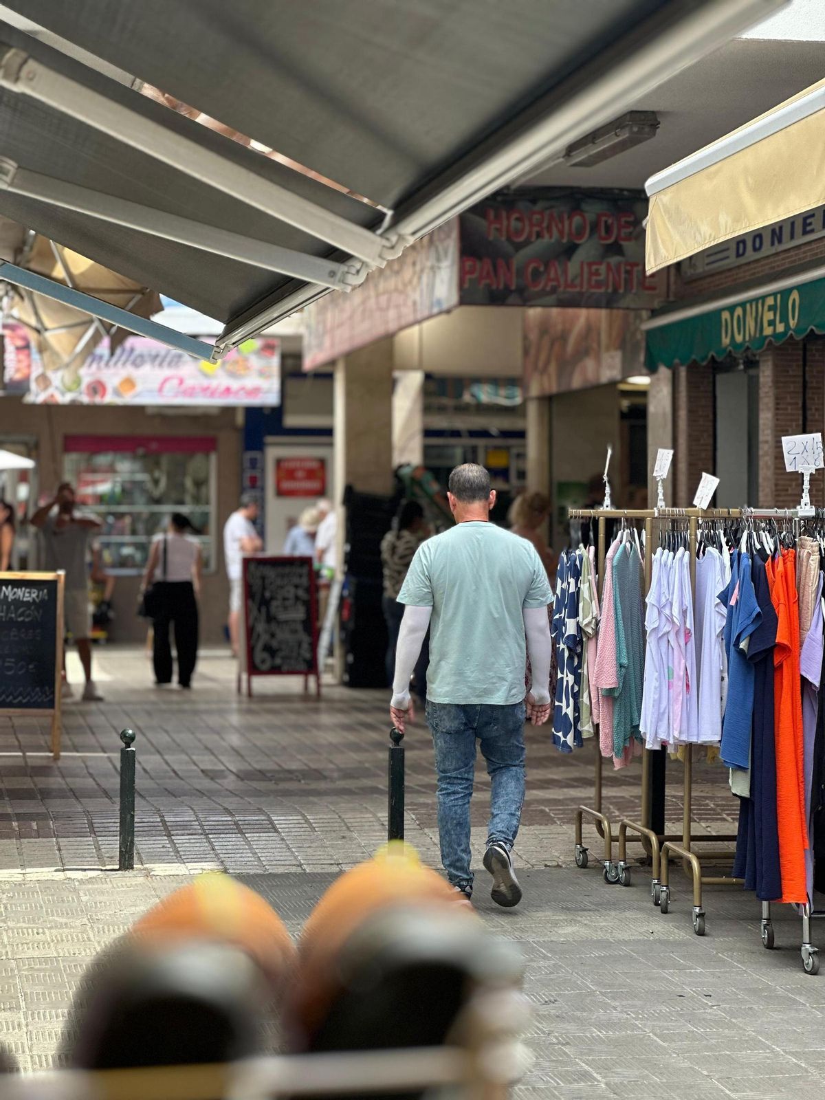 Un vecino pasea por las calles del comercial de Parque Alcosa.