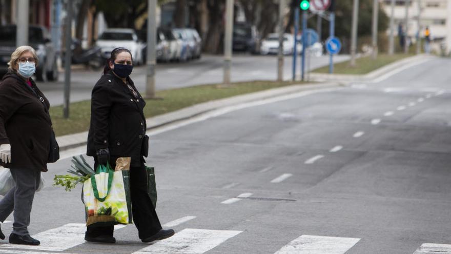 Dos señoras vuelven de la compra en el confinamiento en Alicante