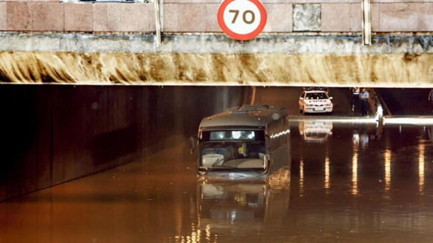 Una guagua de Global atrapada en el agua empozada de los túneles de Julio Luengo, ayer al mediodía. i  EFE