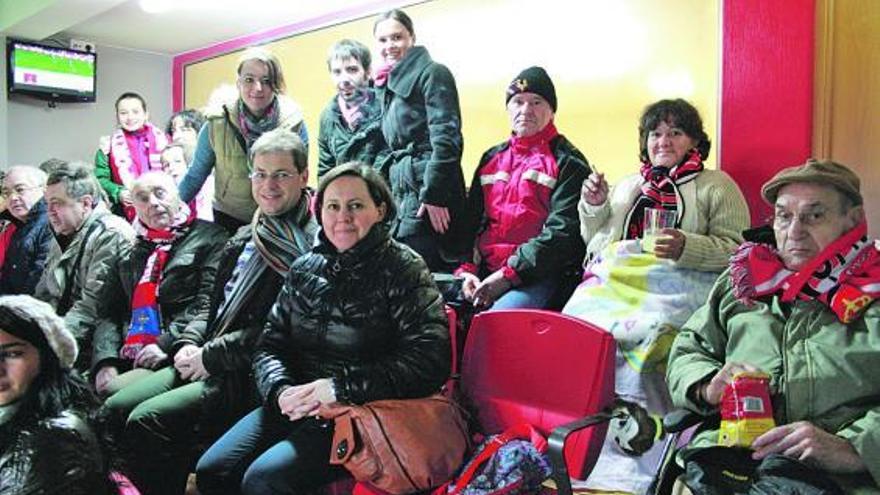 Residentes en sillas de ruedas, bien abrigados y con familiares, ayer, en el palco del Ayuntamiento de Gijón.