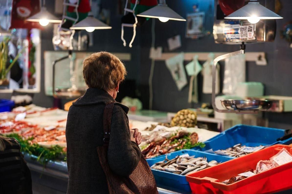 Una mujer compra en una pescadería en el Mercat Nou de Ibiza