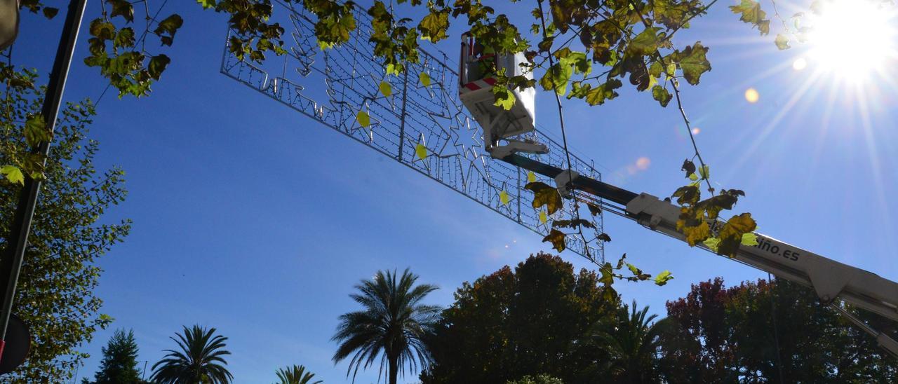 Operarios de la firma Electromiño, instalando ayer los arcos navideños en la Avenida de Castelao