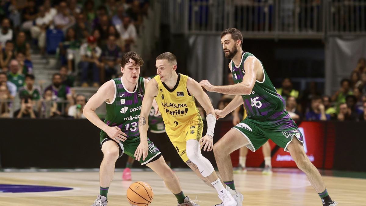 Kyle Guy trata de escapar la marca de Lukosius y Kravish en el Unicaja-Canarias.