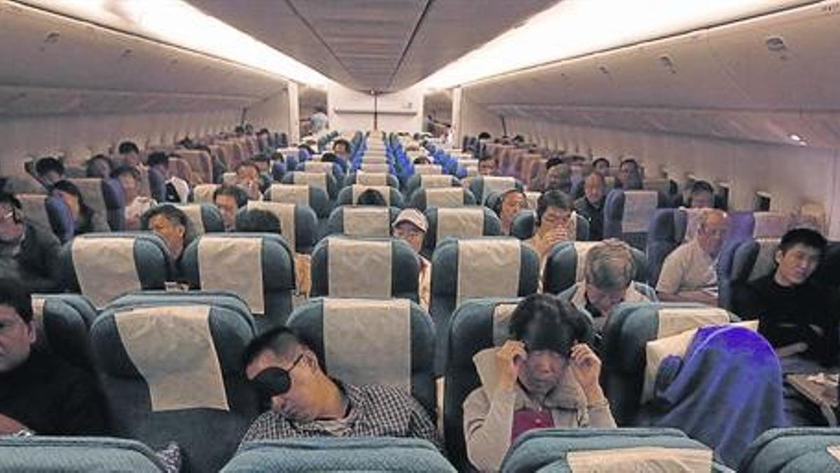 El pasaje del avión de Malaysia Airlines que ha reemplazado al Boeing 777 desaparecido en la ruta hacia Pekín, ayer.