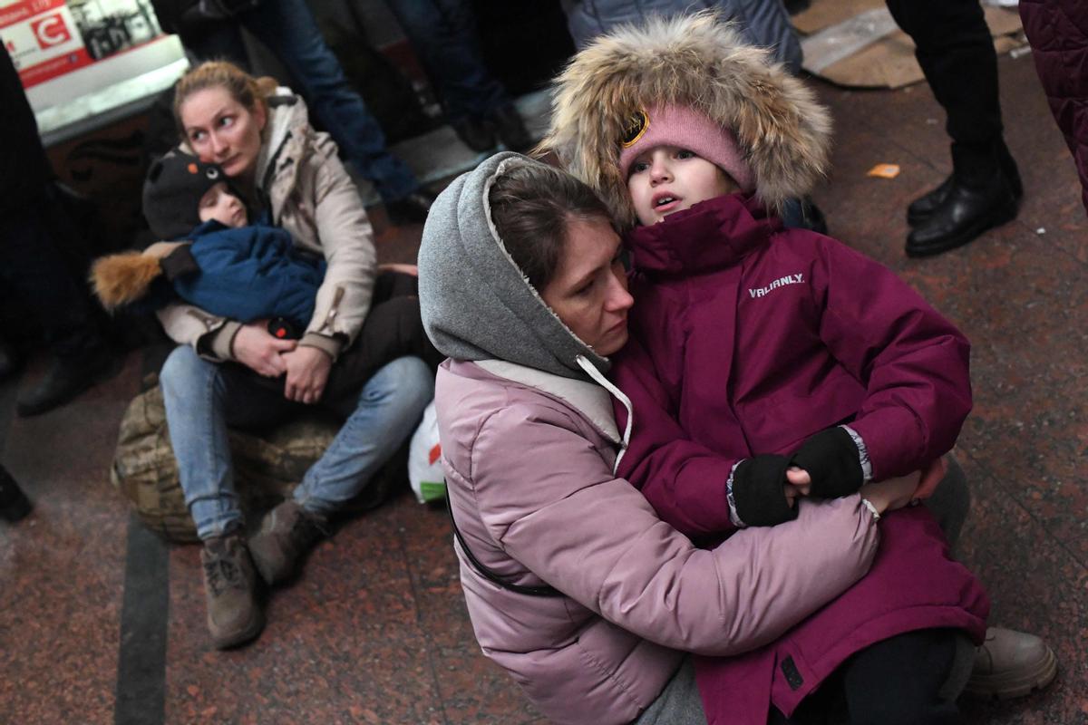 Dos mujeres con sus respectivos hijos sentadas en el suelo de la estación de tren de Leópolis, al oeste de Ucrania.