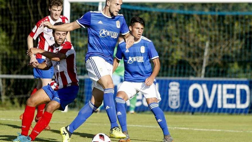 El oviedista Casi protege el balón ante la presión del visitante Quintana.