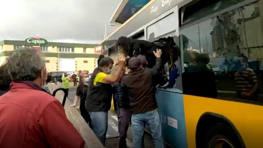 El viento derrumba una valla publicitaria y parte de un muro sobre una guagua en Las Palmas de Gran Canaria