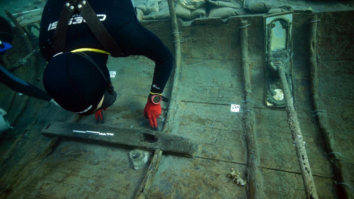 Un arqueólogo subacuático revisa el casco del barco fenicio.