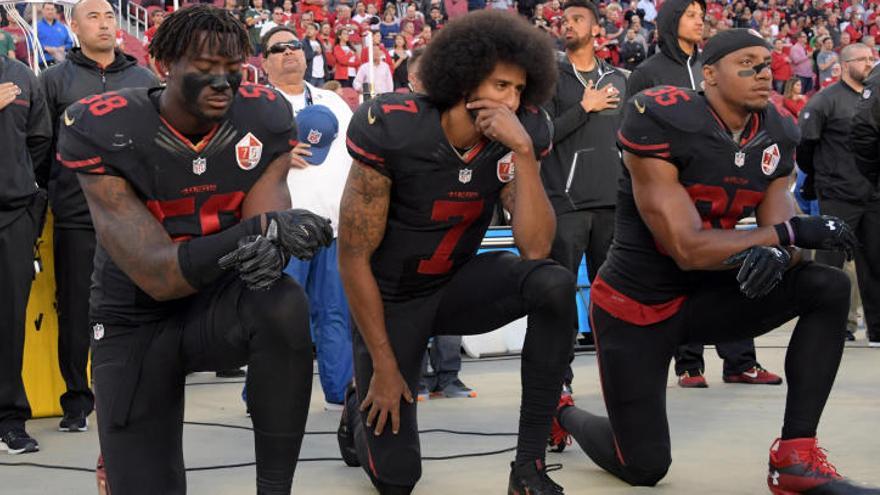 Jugadores arrodillados del San Francisco 49ers en protesta durante el himno