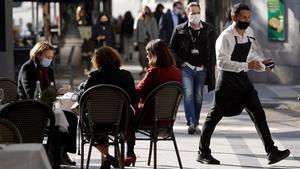 Un camarero trabaja en la terraza de un bar abierto en Madrid. 