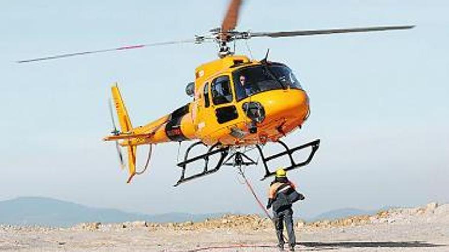 Un operario recoge uno de los cables durante el aterrizaje del aparato. / luisma murias