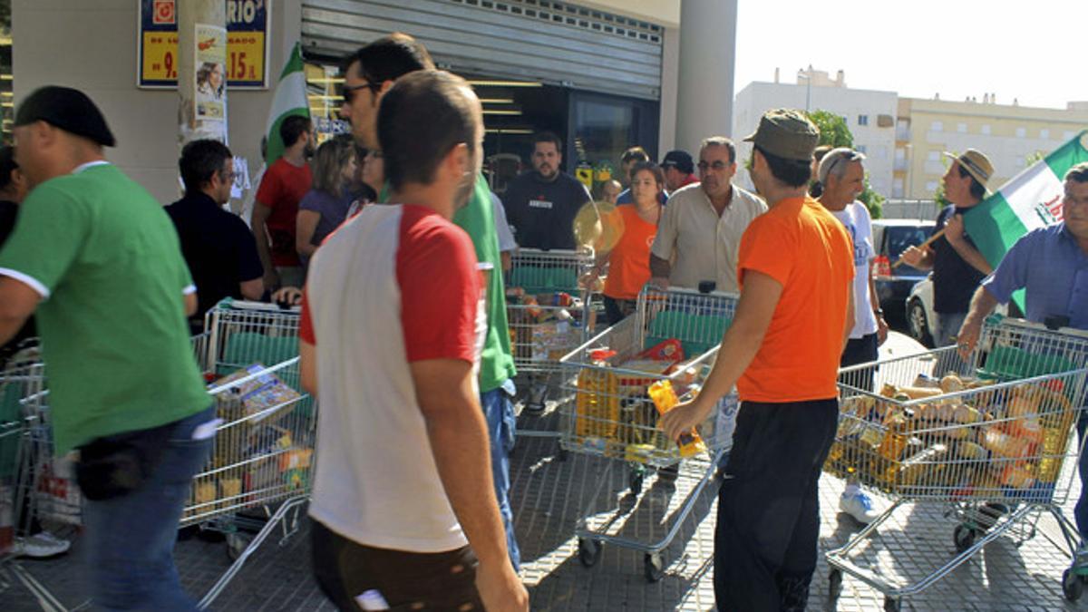 Miembros del Sindicato Andaluz de Trabajadores, el martes en Écija (Sevilla), durante el asalto a un supermercado.