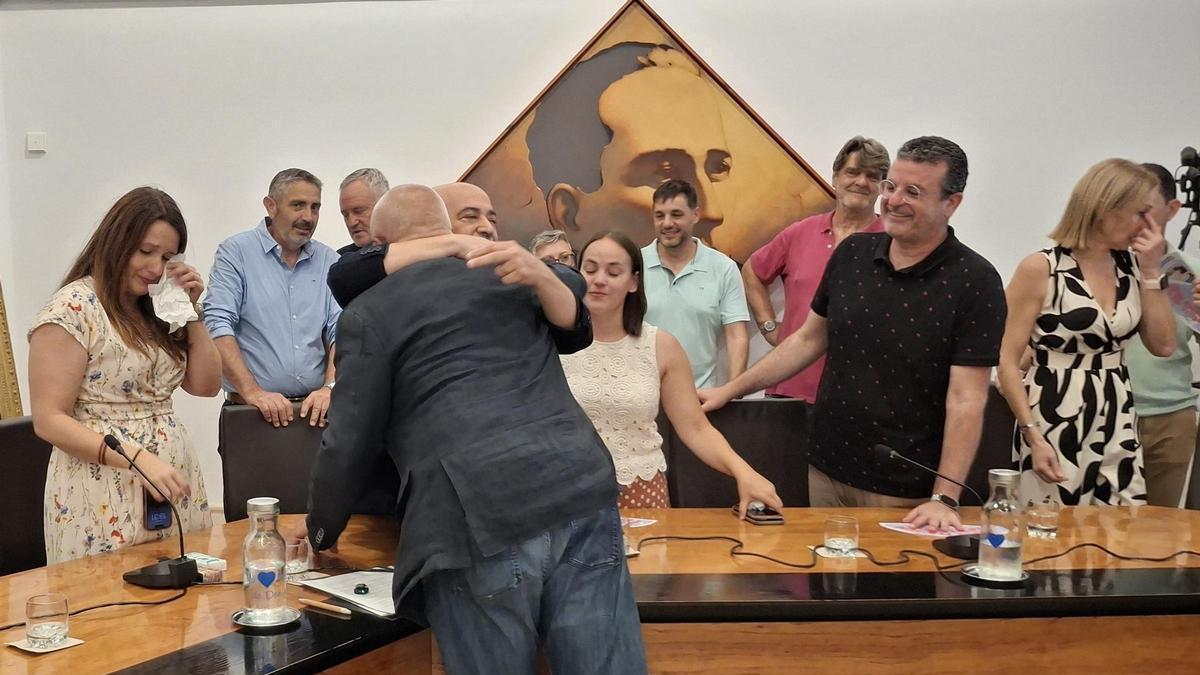 Vicent Grimalt, de espaldas, se abraza con Javier Scotto mientras la concejala Sandra Gertrudix se enjuga las lágrimas