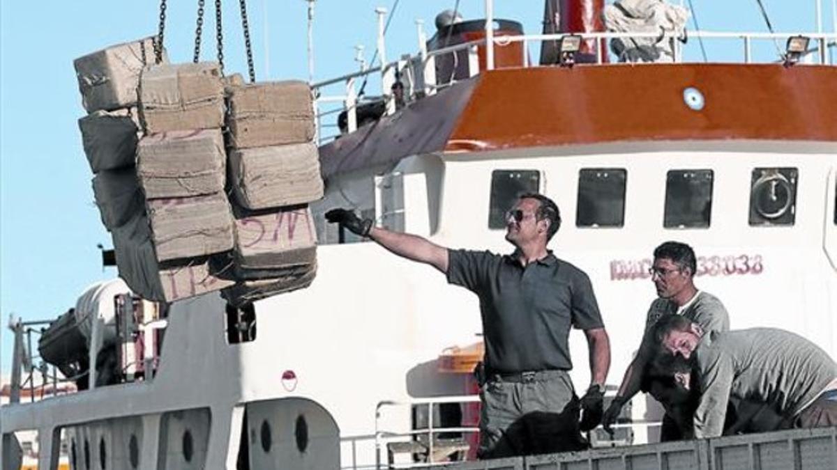 Descarga en el puerto de Almería de los fardos de hachís incautados en un buque apresado en el mar de Alborán, el pasado abril.