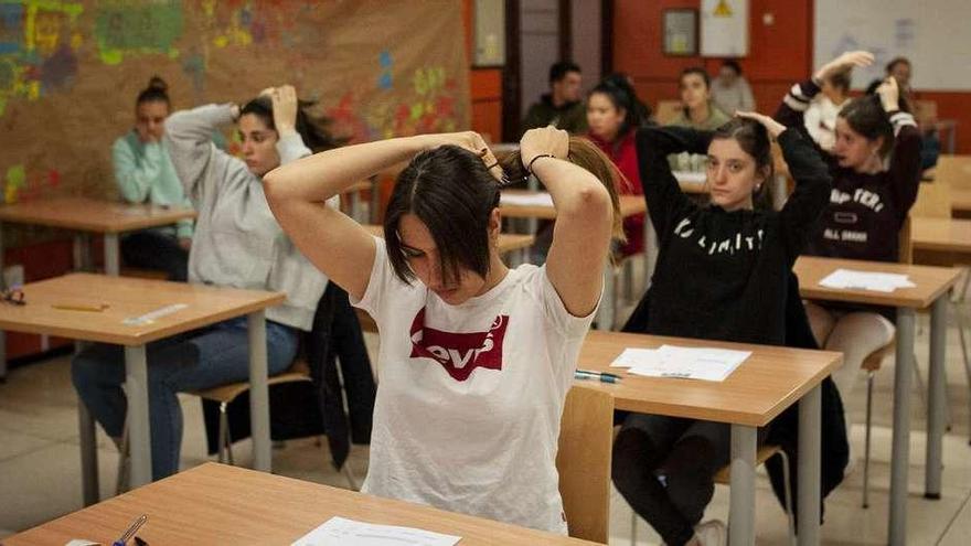 Varias alumnas se recogen el pelo antes de iniciar el examen de Historia de España, en una de las aulas del edificio de Ferro. // Brais Lorenzo