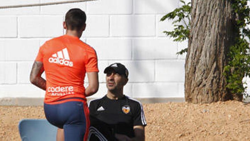 Ayestarán charla con Paco Alcácer, de espaldas, ayer en la ciudad deportiva.