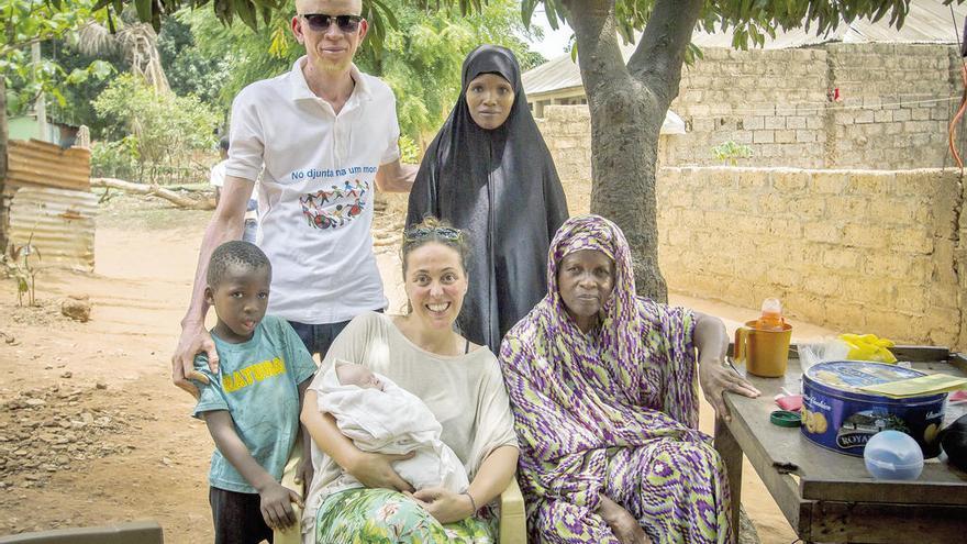 Marta Moreiras, con parte de la familia Darame, en Guinea Bissau, que suma seis miembros albinos. Uno de ellos es Brahima (arriba), conocido activista. A su lado, Nafi Cissé, madre de Sumaila, la bebé albina que tiene Marta en brazos, del pequeño Moussa (a su derecha) y de otros dos hijos. A la izquierda de la gallega, la matriarca de la familia, Mafanta Cissé. // Pepe Naranjo