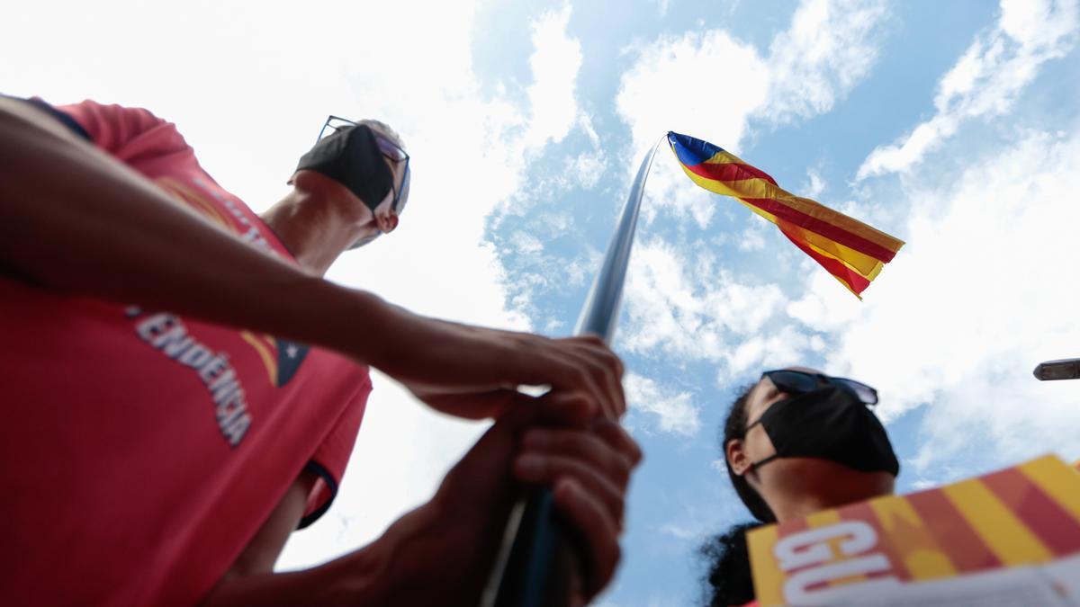 Dos manifestants aguanten una senyera durant la manifestació de l&#039;ANC per la Diada de l&#039;11 de setembre del 2021 a Barcelona