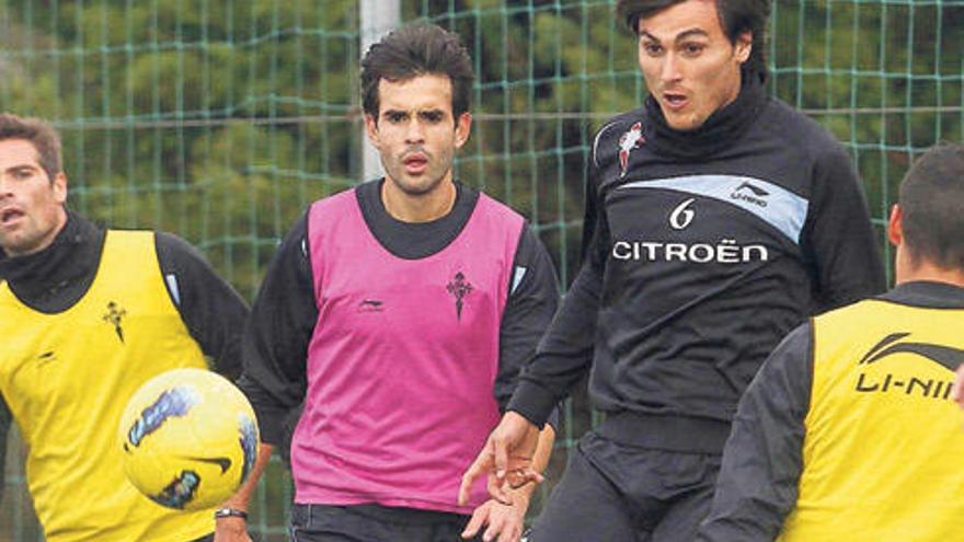 Jonathan Vila golpea el balón ante la atenta mirada de Borja Oubiña y Quique de Lucas. // Ricardo Grobas