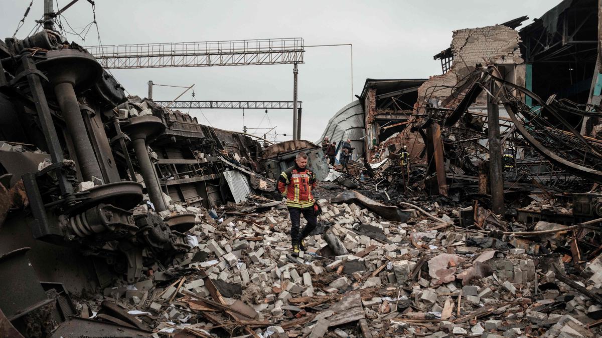 Un bombero camina entre los escombros de una estación de tren en Járkov, parcialmente destruida por el ataque de un misil, en un ataque durante la guerra en Ucrania