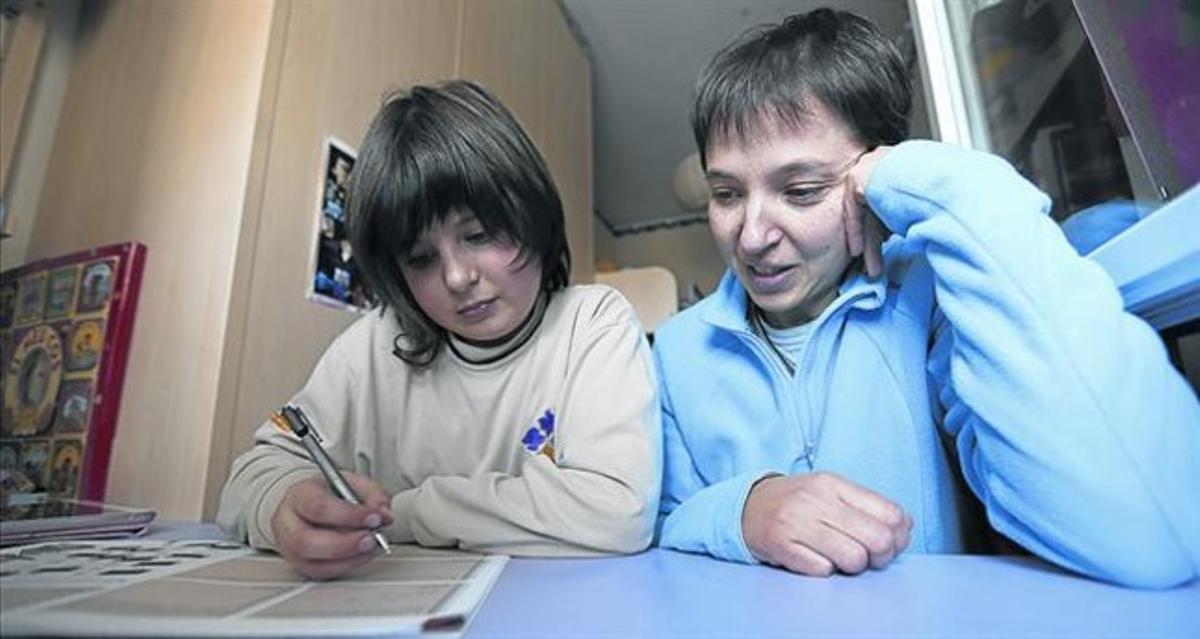 Al casal 8 Una monitora ajuda un noi al Casal dels Infants, al Raval.