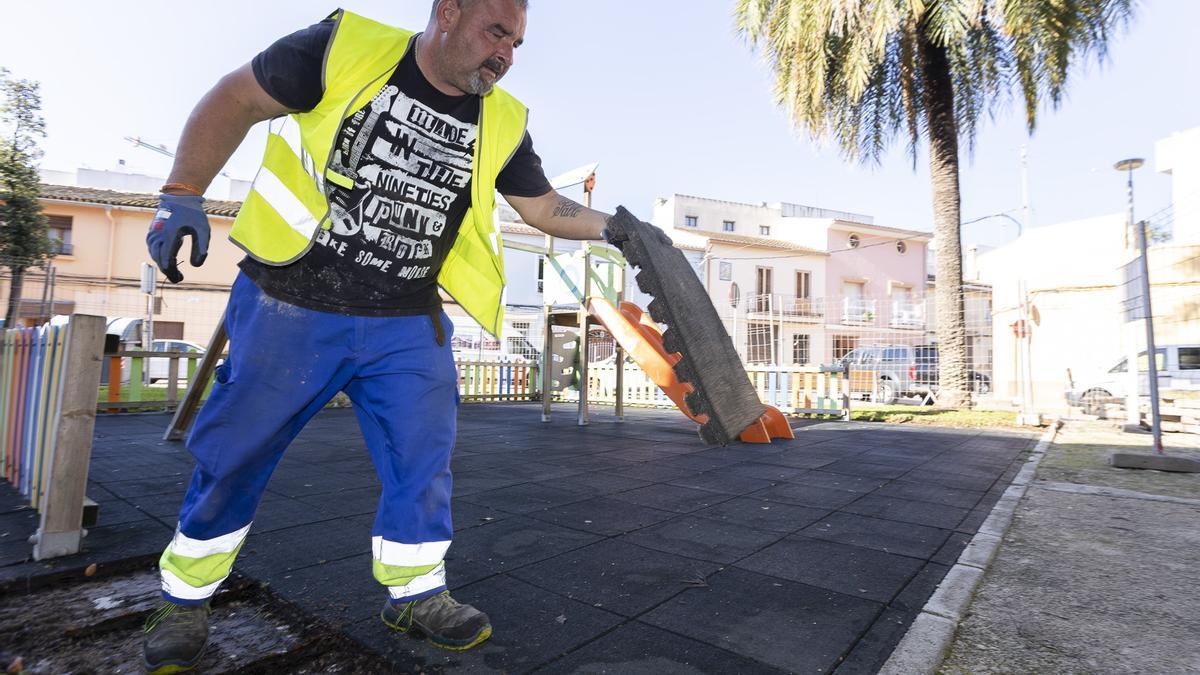 Un operario retira el caucho de un parque infantil de Gandia para renovarlo.