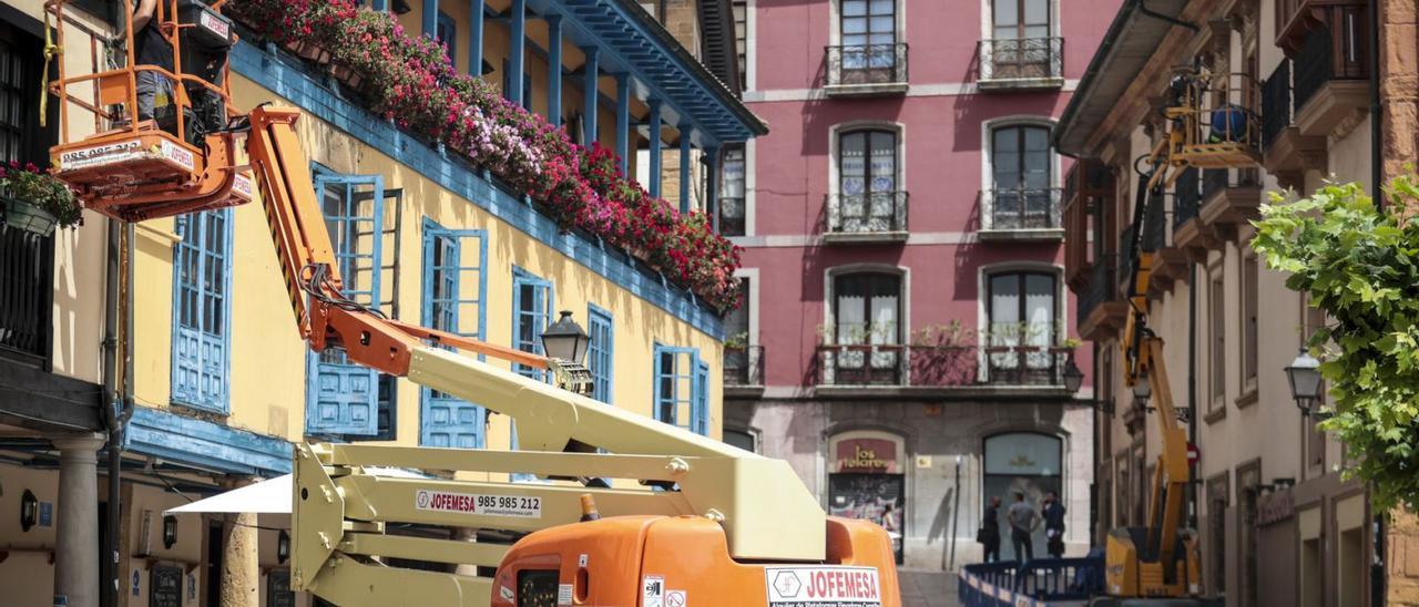 Trabajos, ayer, en las casas del Fontán; en el círculo, un detalle de las labores de pintura. | Irma Collín