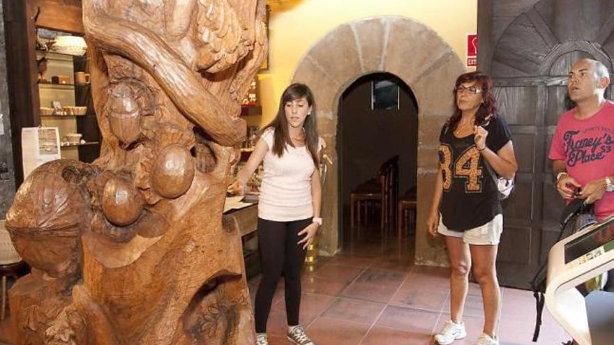 Eva Aladro, ayer por la tarde, mostrando a dos visitantes el Museo de la Madera.