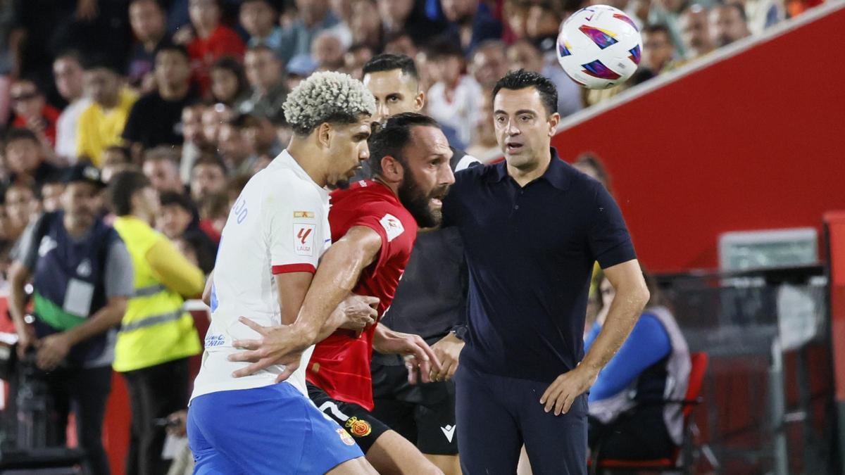 Araujo presiona a Muriqi junto a la línea de banda donde está Xavi. Araujo presiona a Muriqi junto a la línea de banda donde está Xavi.