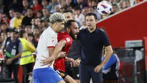 Araujo presiona a Muriqi junto a la línea de banda donde está Xavi.