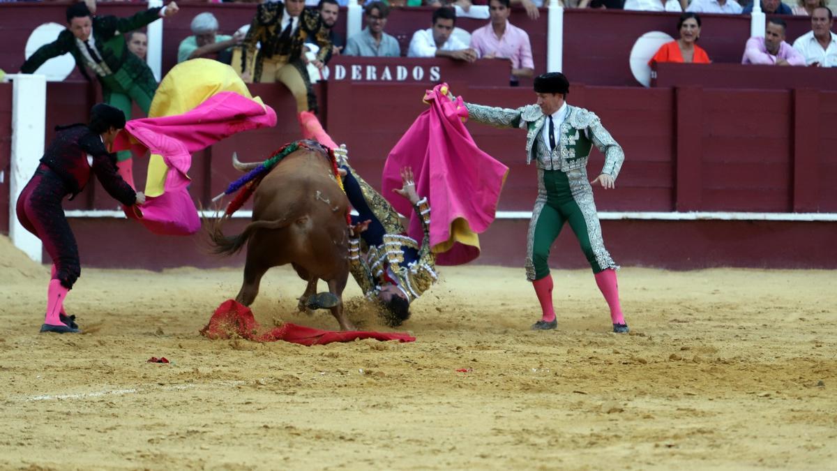 Momento en el que el diestro Jiménez Fortes cae al albero de La Malagueta tras ser embestido por el toro.