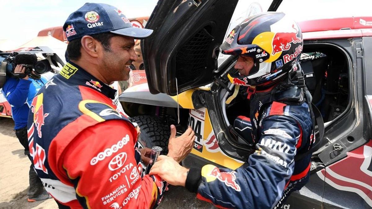 El catarí Al-Attiyah y el francés Peterhansel se saludan, hoy, tras una bella batalla en las dunas de Perú.