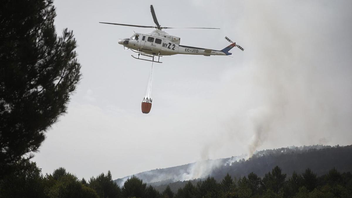 Helicóptero a punto de descargar agua sobre el incendio en Sarracín de Aliste.