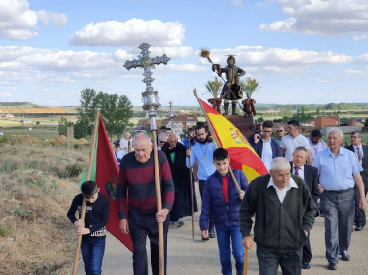 El alcalde porta la cruz de plata procesional. | E. P.