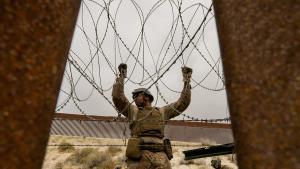 Un integrante del ejercito de Estados Unidos refuerza un muro con alambre de púas este jueves, en la frontera con la ciudad de Tijuana