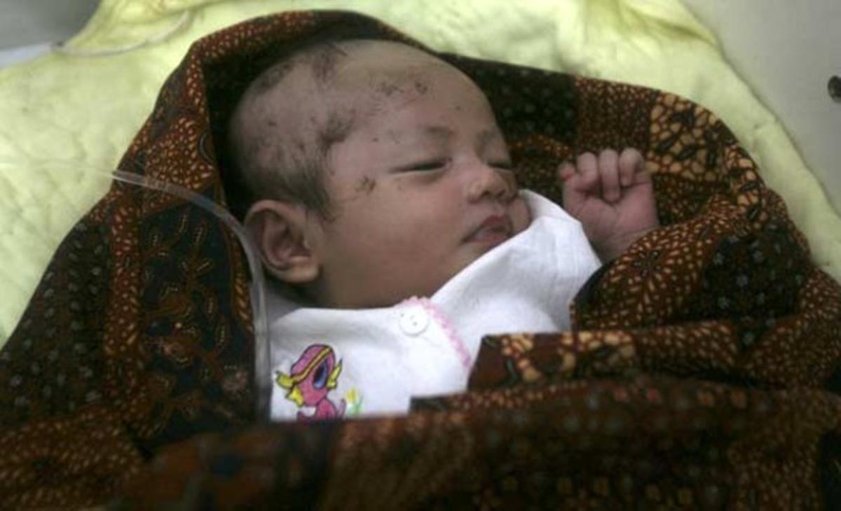Un recién nacido huérfano descansa en el hospital de Sikakap (Indonesia). El pequeño fue hallado tras el tsunami que esta semana ha arrasado la zona, provocando numerosas muertes y cientos de desapariciones.