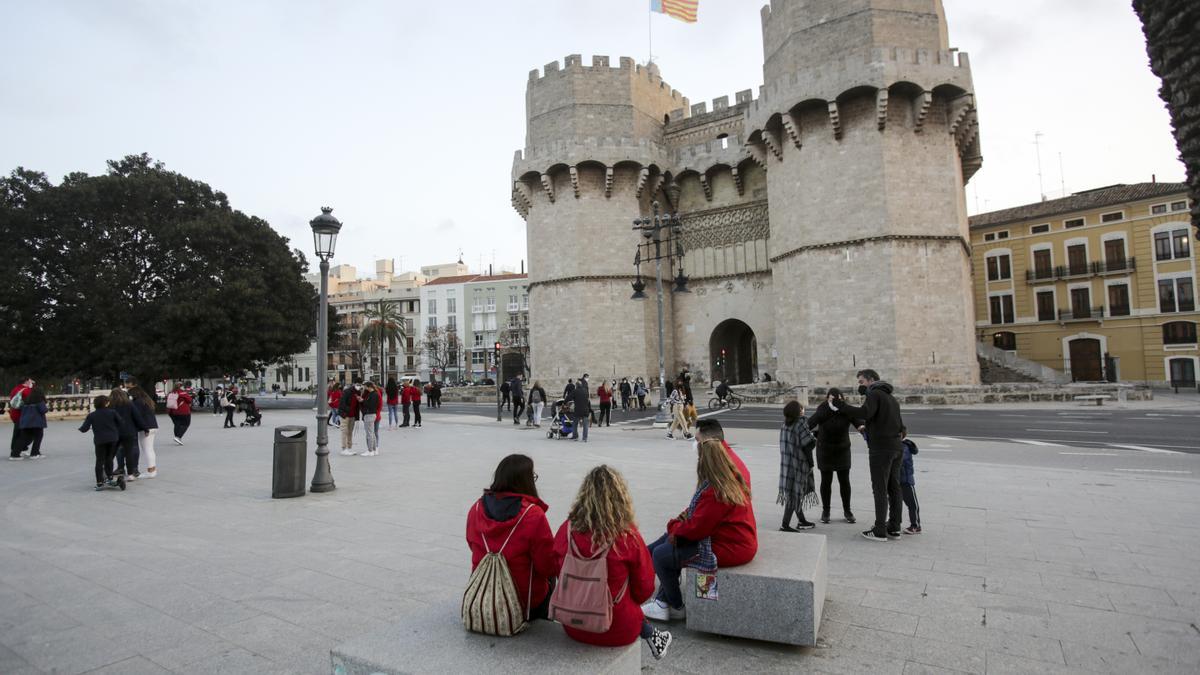 Falleros y falleras, distinguibles por los polares, en la plaza de la Crida.