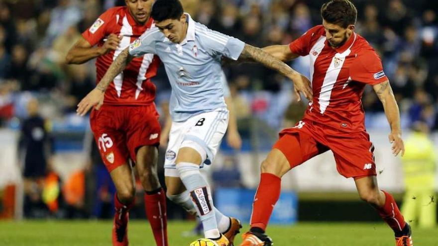Hernández controla el balón ante dos jugadores del Sevilla. // Marta G. Brea