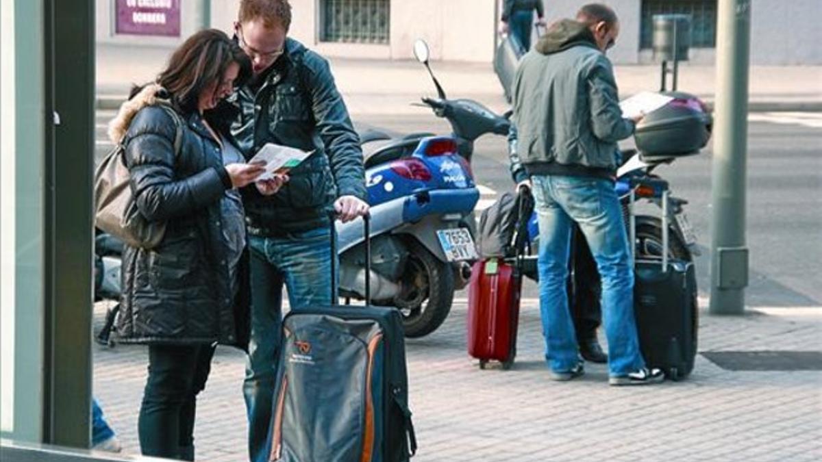 Dos turistas holandeses, a su llegada a Barcelona, tras salir de la estación de Renfe por la calle de Aragó.