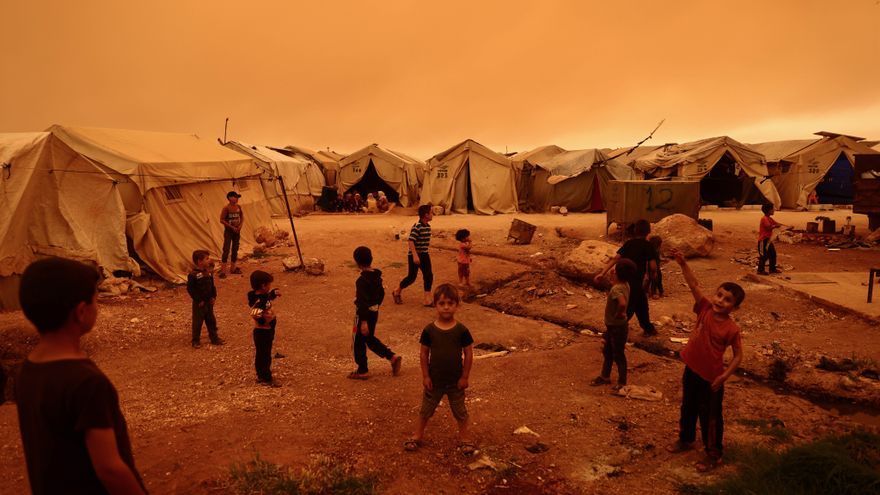 Niños jugando durante una tormenta de arena en un campamento de desplazados en Siria.