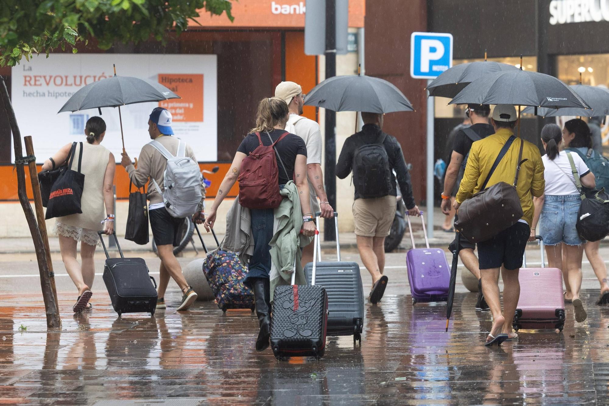 Varias personas con maletas durante un episodio reciente de lluvias en Vila.