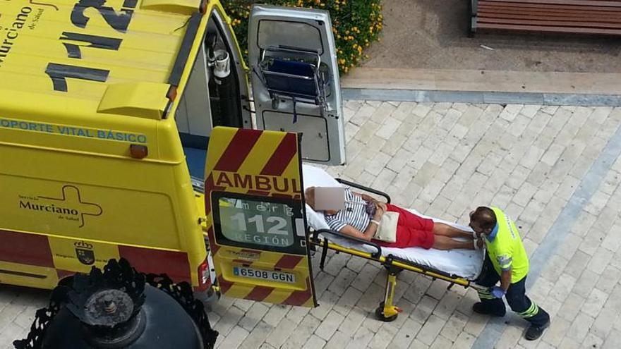 Una de las personas heridas es llevada a la ambulancia.